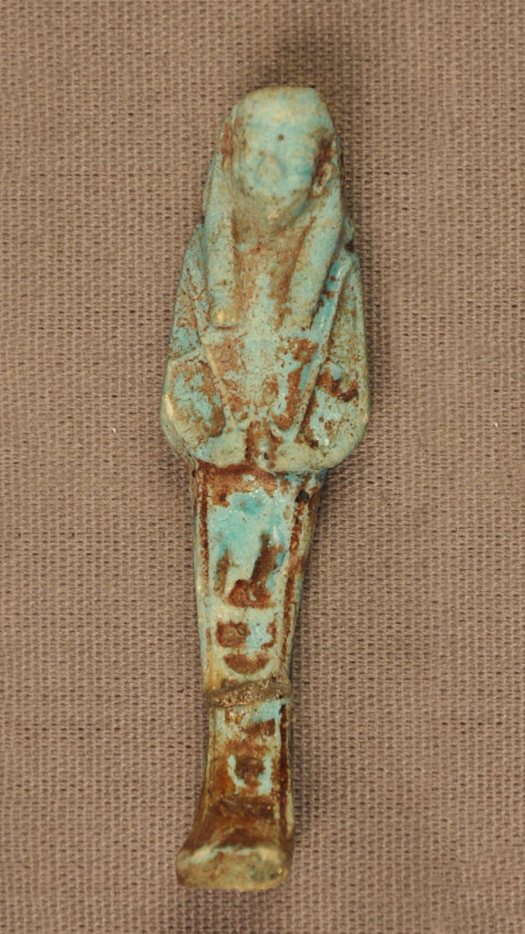 green stone carving of a mummy with brown substance