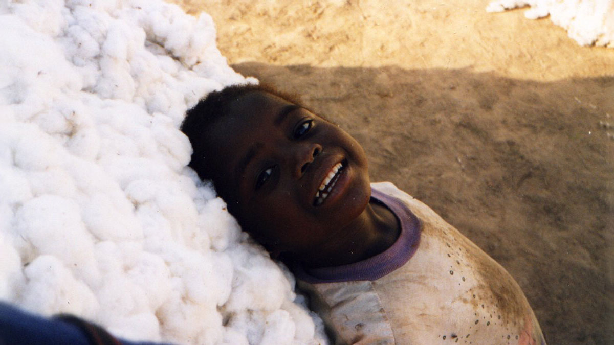 a child leaning against a mound of cotton