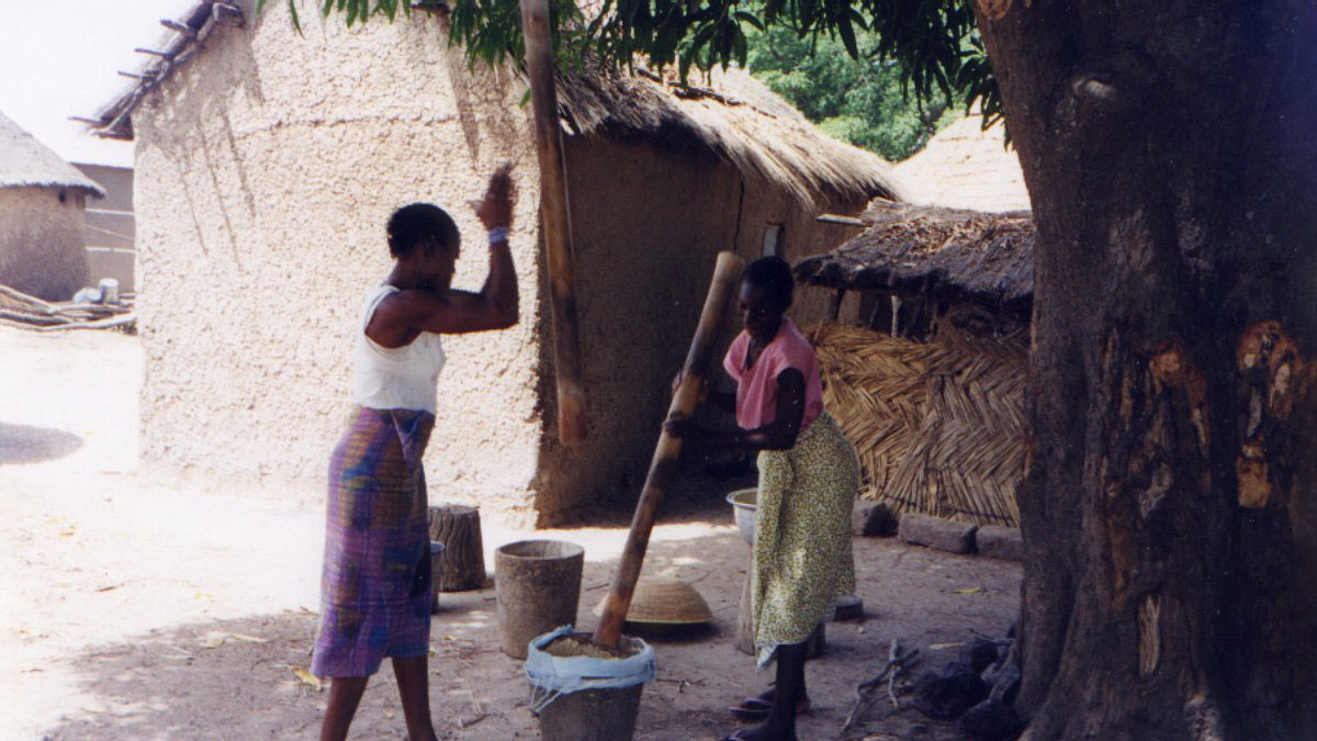 two girls pounding grain